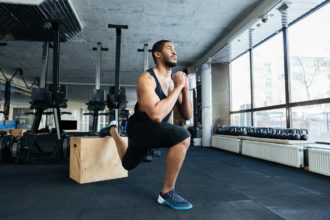 Muscular fitness man doing squats in the gym