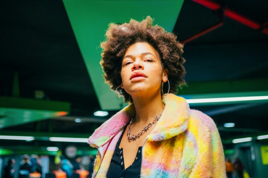 Portrait young curly hair fashionable and confident black woman indoor looking camera