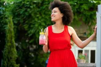 Summer lifestyle fashion portrait of stylish black woman with drink