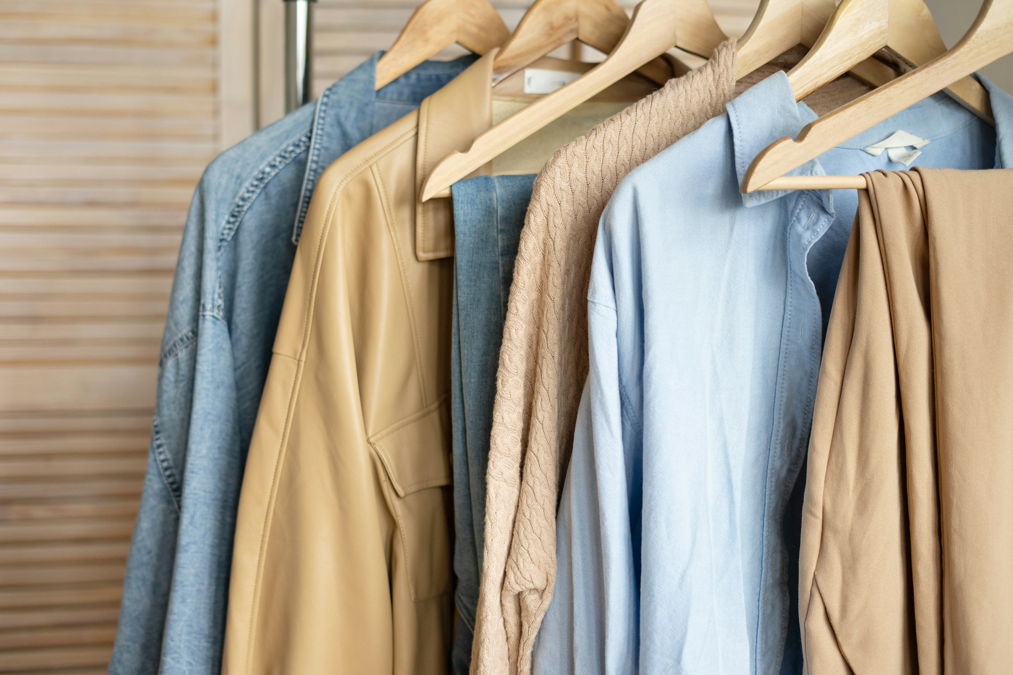 Trendy capsule wardrobe in beige and light blue on a rail rack